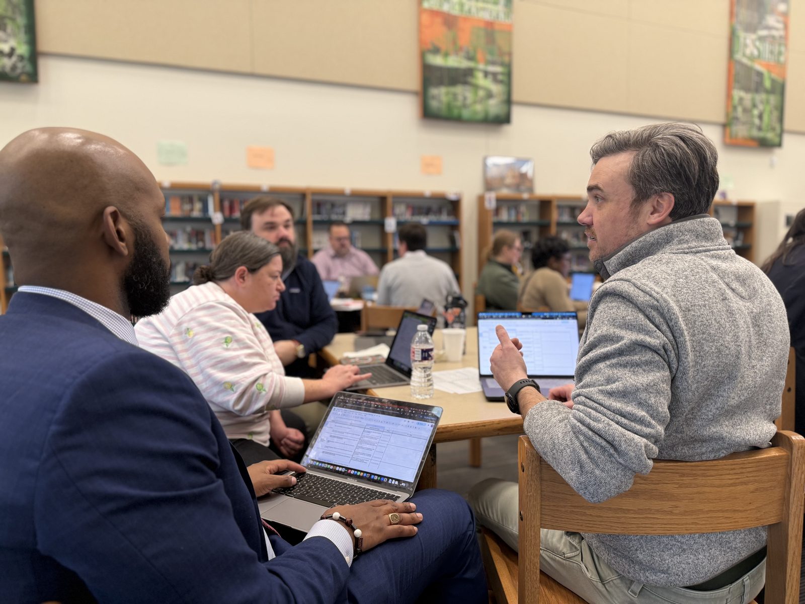New Orleans school leaders working together around laptops